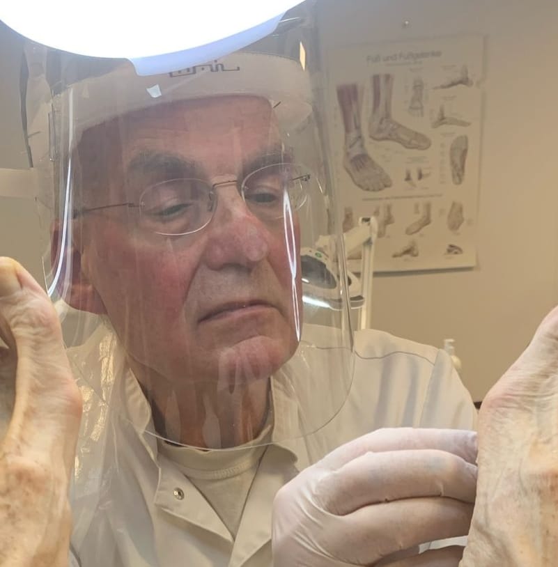 Ruben Kuyper, pedicure in Amersfoort, behandelt de voeten van een cliënt onder een werklamp